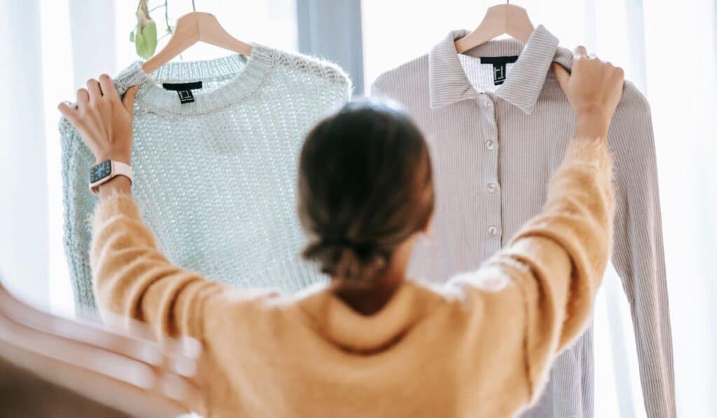 a lady holding up two shirts