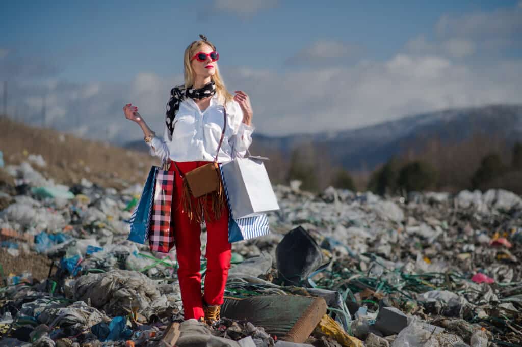 a lady with shopping bags standing on a large landfill