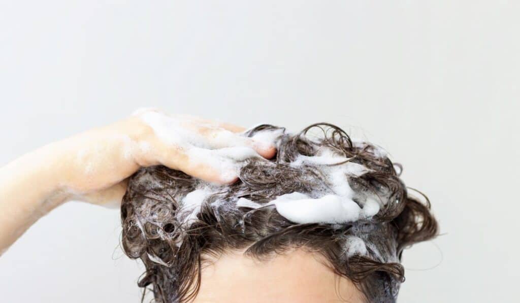 a person washing their hair with shampoo