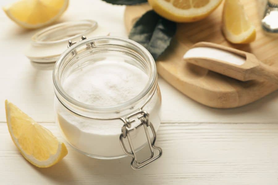 a jar of baking soda next to a wood cutting board