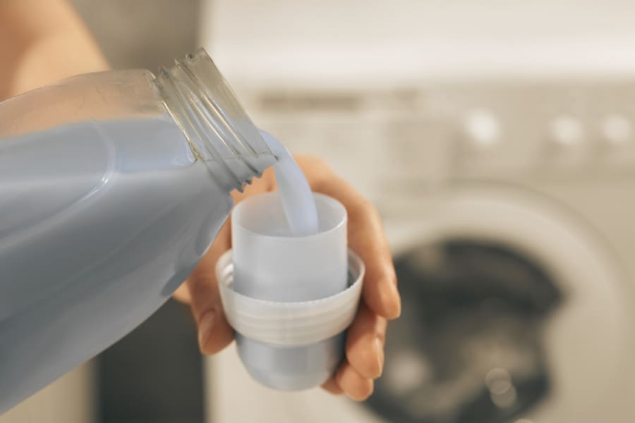 pouring fabric softener into a cap