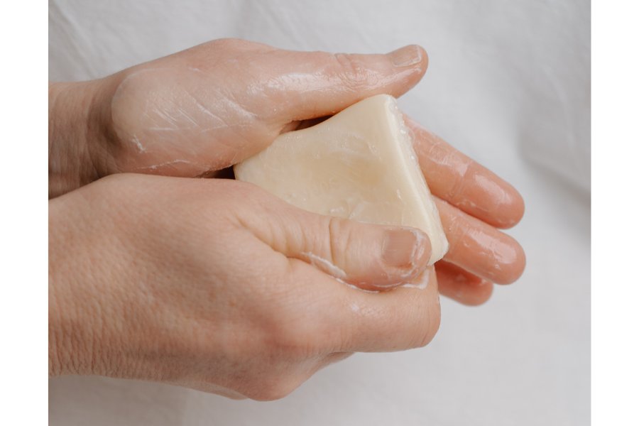 a person washing their hands with natural soap