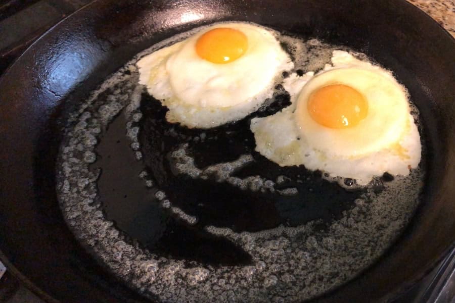 eggs cooking on a cast iron skillet