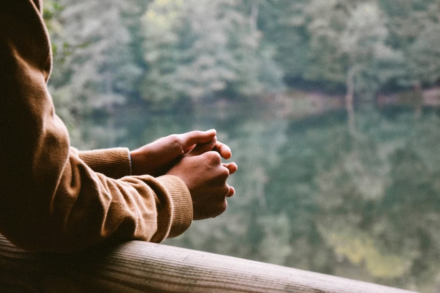 a person meditating at a lake