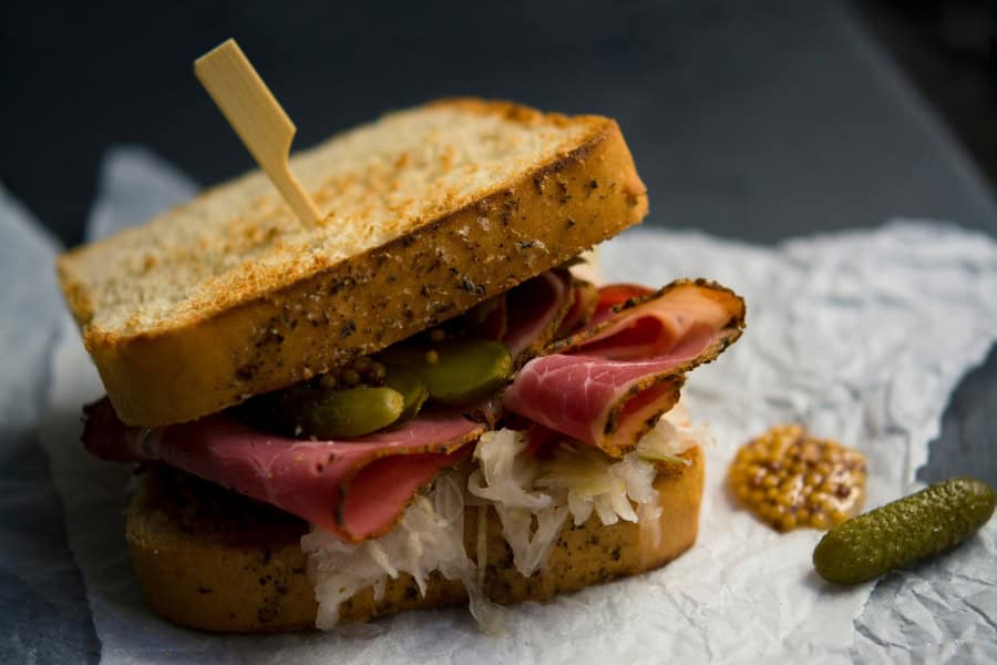 A sandwich with sourdough bread, pickles and roast beef