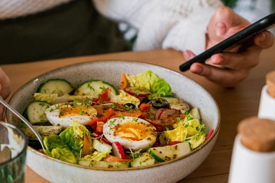 a person eating while scrolling on their phone