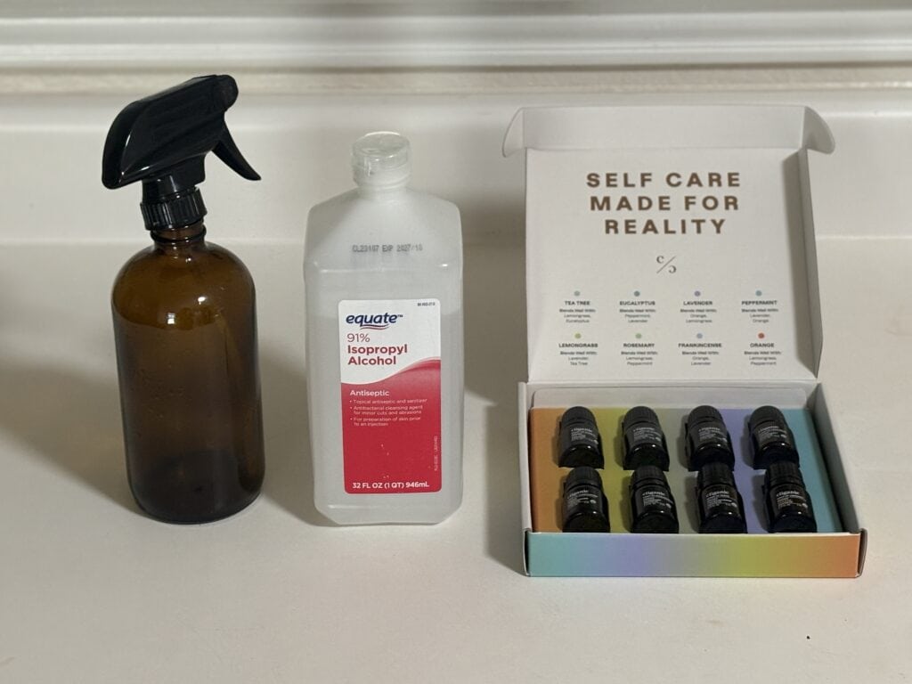 a glass bottle, rubbing alcohol bottle, and a set of essential oils