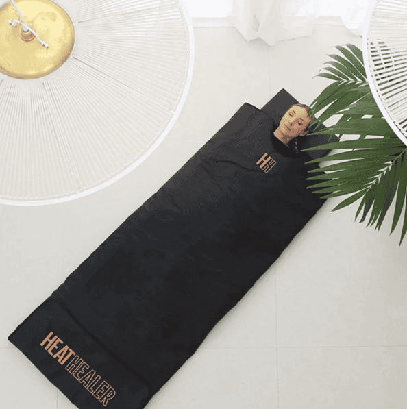 a lady laying in a sauna blanket