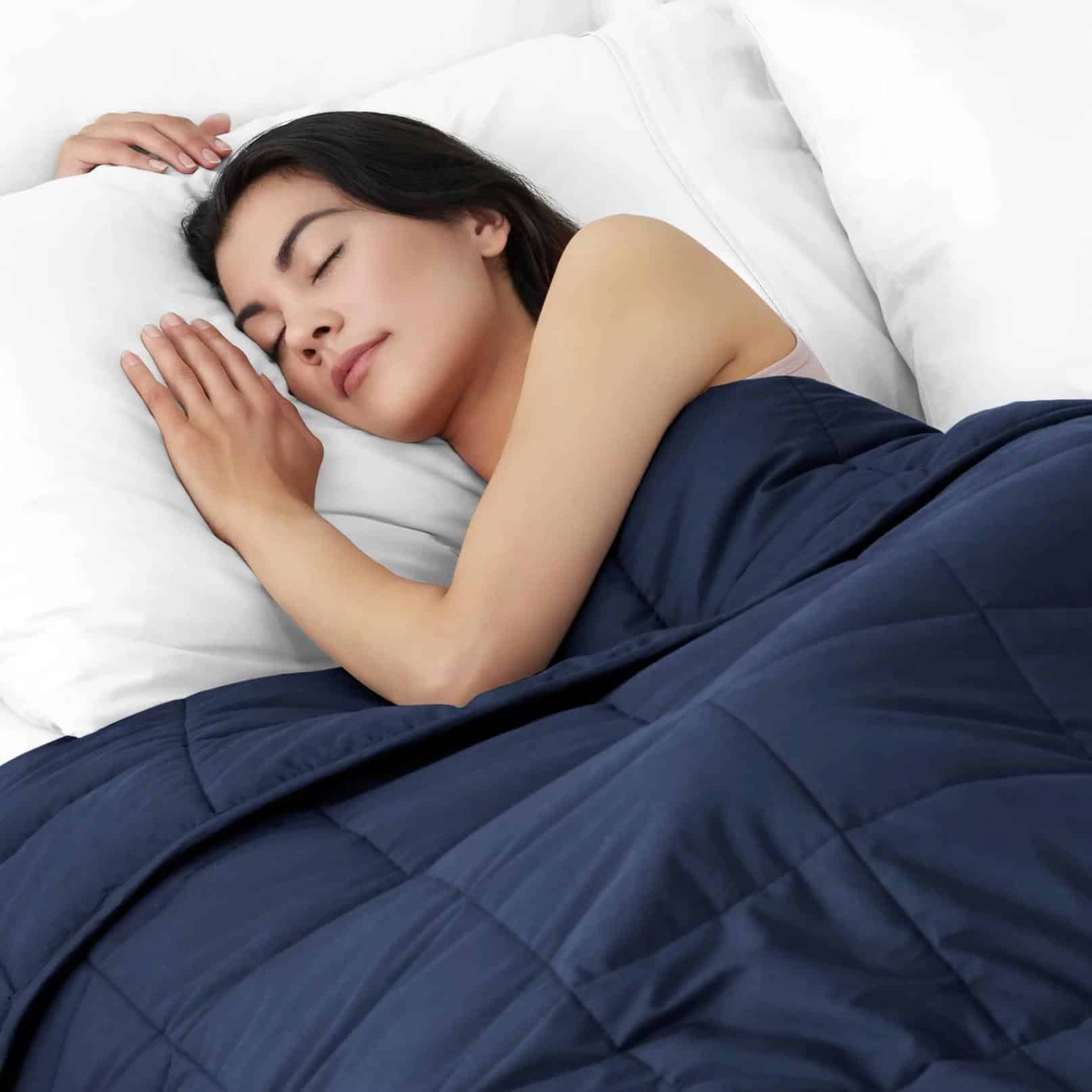 a woman sleeping comfortably under a toxic free weighted blanket