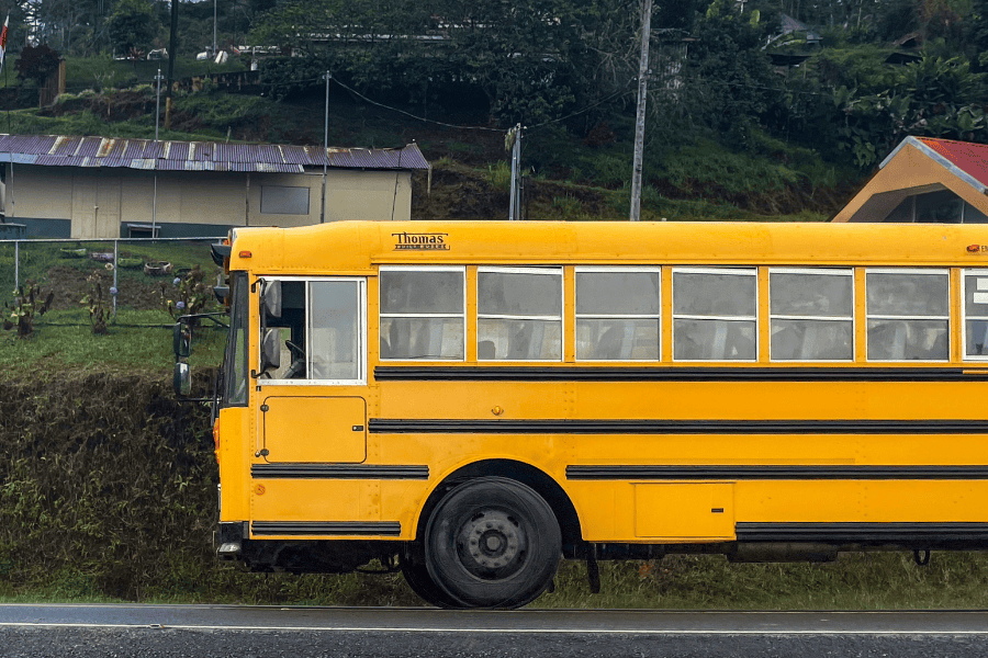 A school bus driving through a rural, low income area
