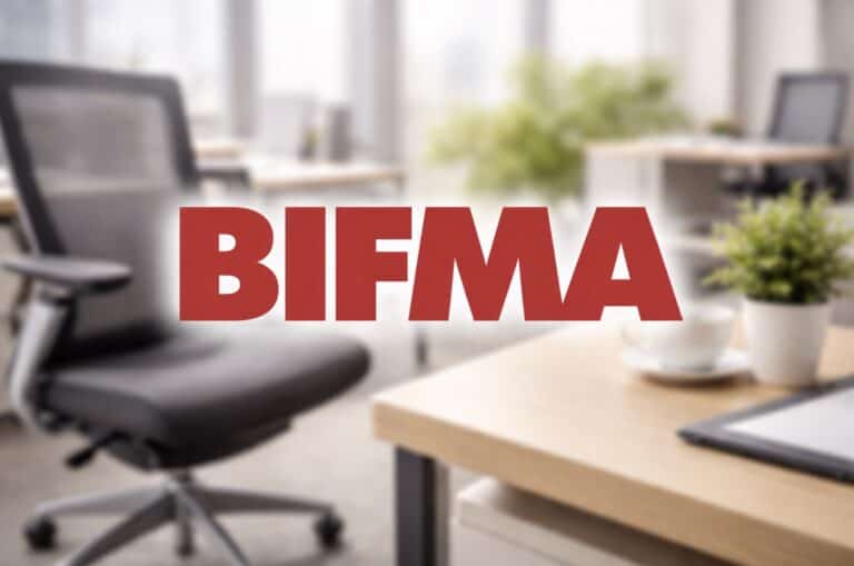 Red BIFMA logo centered over a blurred modern office background with desk and ergonomic chair