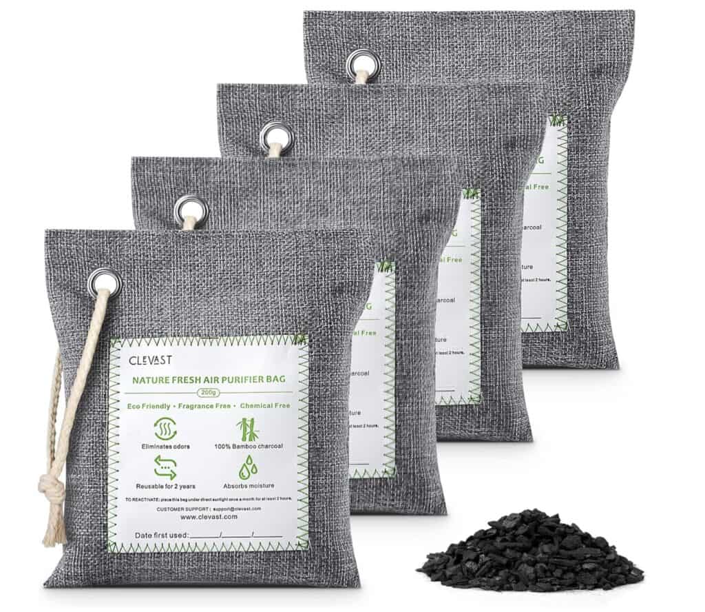 Set of gray fabric bamboo charcoal air purifying bags with hanging loops, shown with loose charcoal pieces on a white background