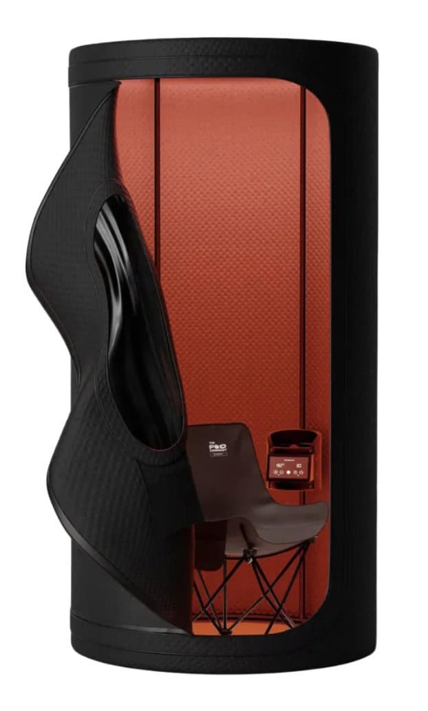 Compact portable infrared sauna pod with seated interior and red heat panels