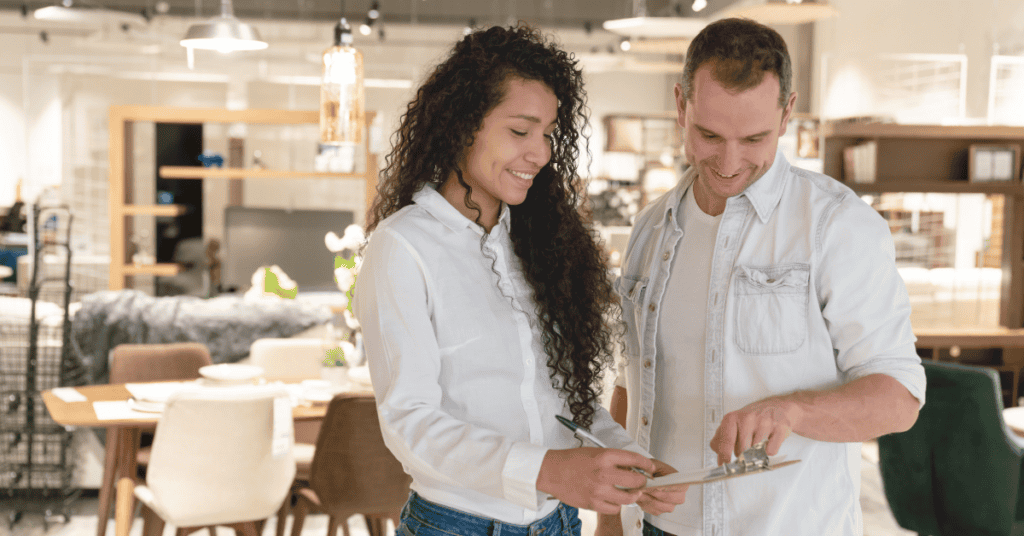 Couple reviewing furniture details while shopping in a furniture store