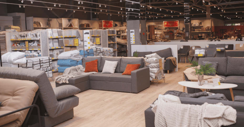 Modern furniture store with couches, pillows, rugs, and home decor displays.