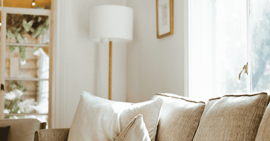 Close-up of a beige couch beside an open window