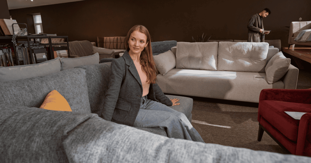 Woman testing a couch in a furniture showroom