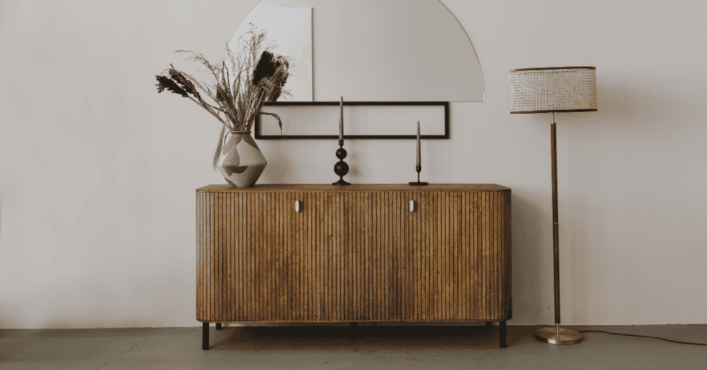 Wooden sideboard in a neutral room with simple home decor.