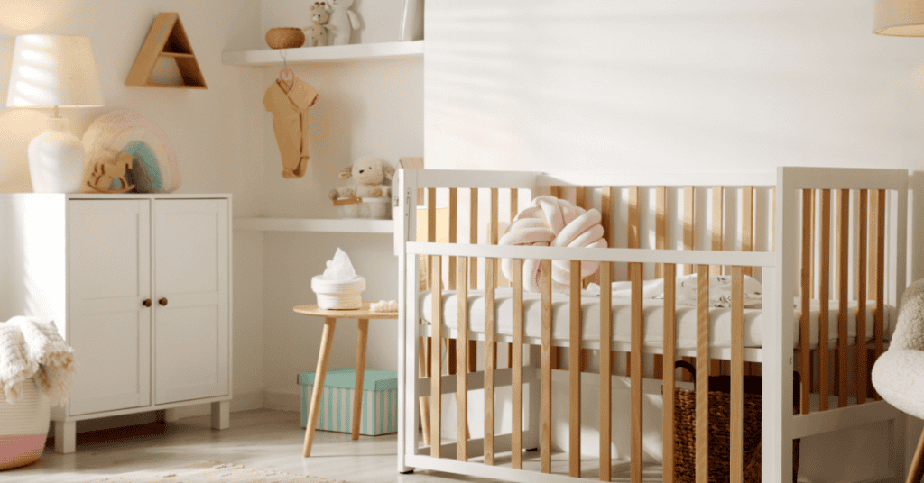 Warm nursery with a wooden crib, storage cabinet, and soft natural lighting.