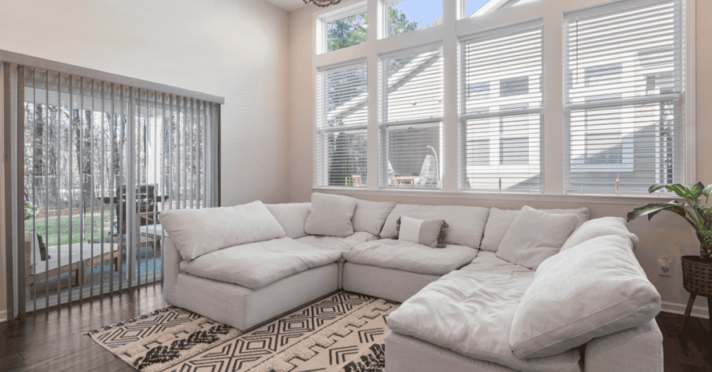 White sofa in a bright living room with large windows for airflow