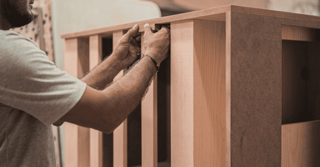 Person assembling a wooden cabinet made from engineered wood panels