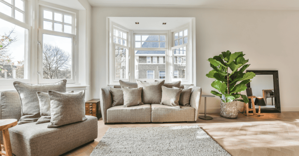 Bright living room with gray sofas, large open windows, and natural light.