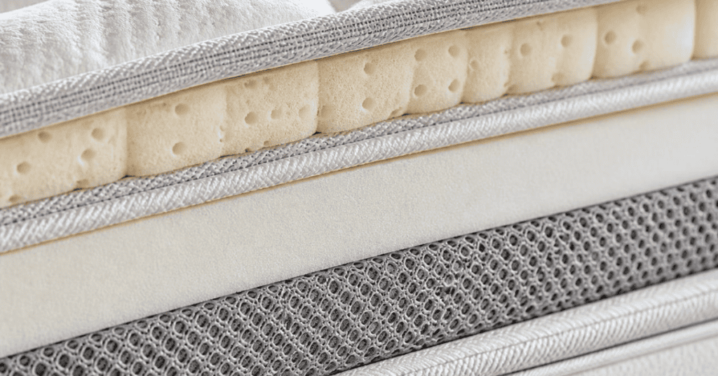 Close-up of layered mattress materials showing foam and fabric construction.