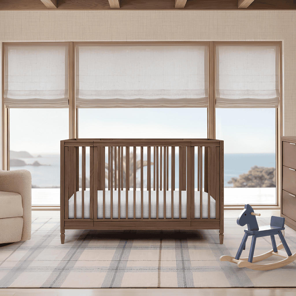 Dark wood Delta Children crib in a bright nursery overlooking the ocean.