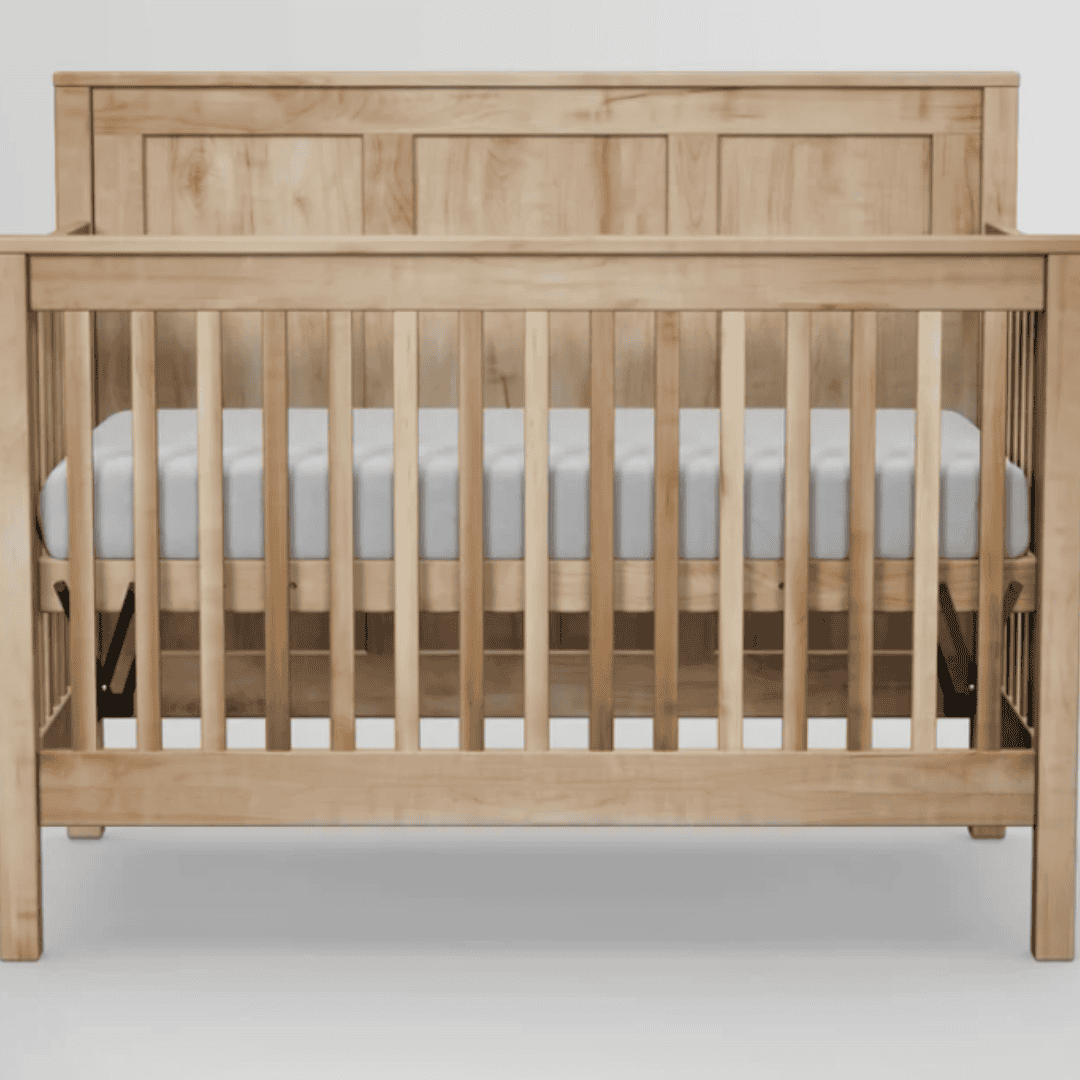 Natural solid wood Green Cradle crib with a fitted mattress on a neutral background.