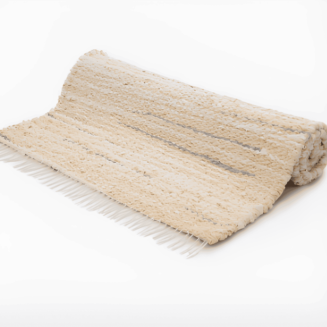 Folded cream handmade rug with gray stripes and white fringe.