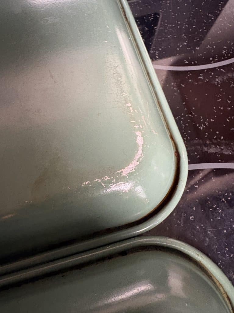Green undersides of two Caraway baking sheets showing scratches, scuffs, and discoloration