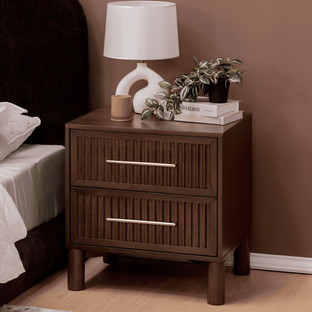 Dark wood two-drawer nightstand styled beside a bed.