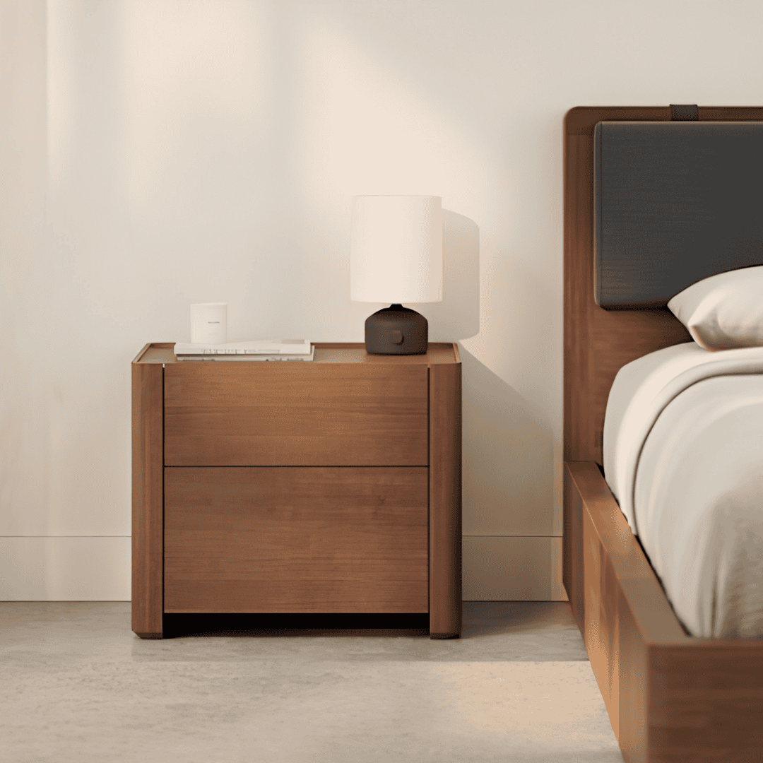 Two-drawer wood nightstand with a lamp beside a modern bed.